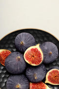 Black Mission fig cut open to show reddish-pink pulp