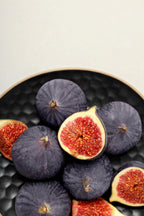 Black Mission fig cut open to show reddish-pink pulp