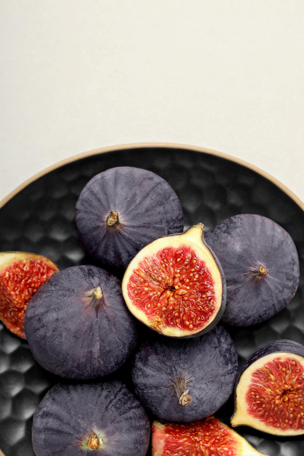 Black Mission fig cut open to show reddish-pink pulp