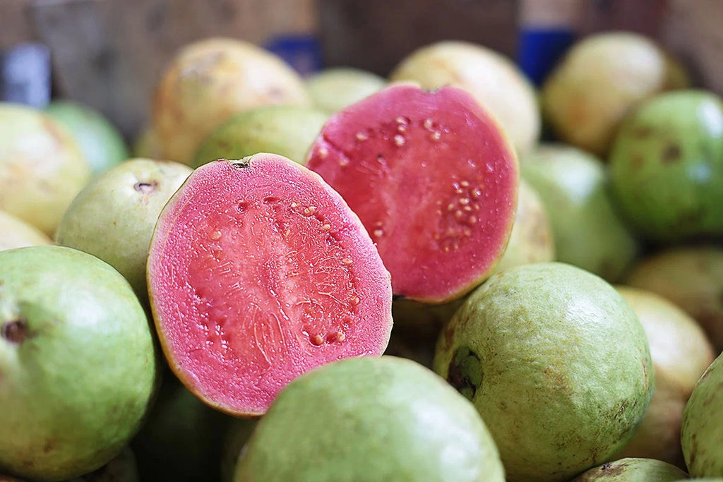 Pink Indian guava cut open to show its reddish flesh
