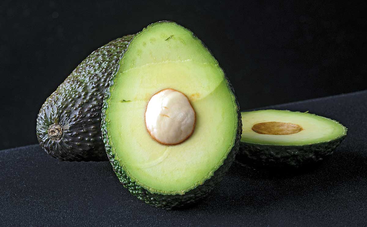 Super Hass avocado cut open to show its flesh and seed